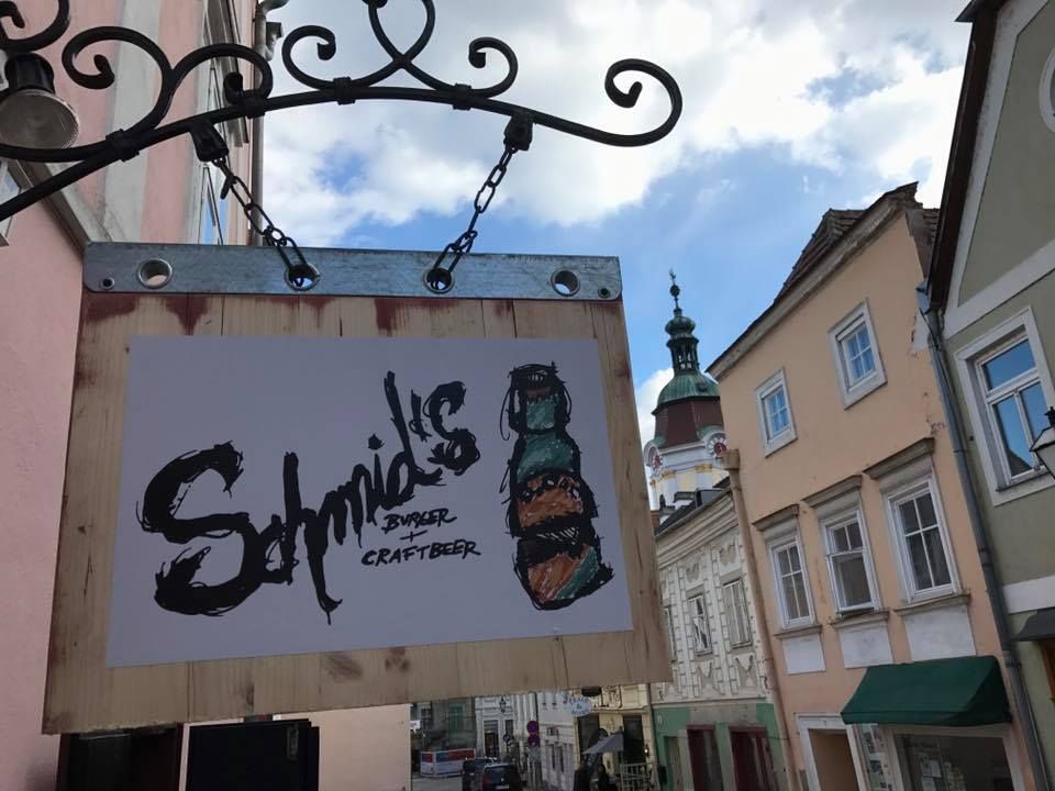 A Schmid's Burger és Craftbeer felirata egy régi városi utcában lévő ház falán.