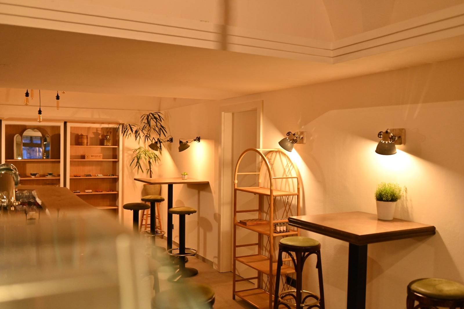 Egy hangulatos kávézó belső nézete, fa bútorokkal és meleg fénnyel.