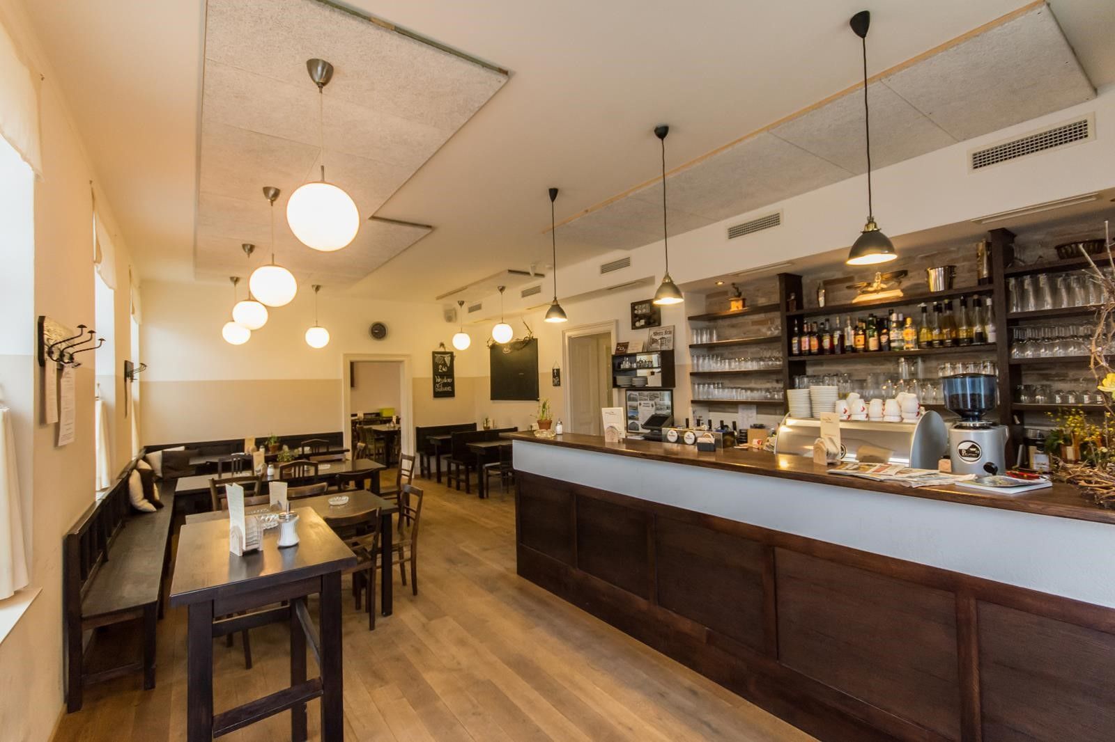 Egy hangulatos, fából készült bútorokkal és bárpulttal berendezett vendéglő belső nézete.