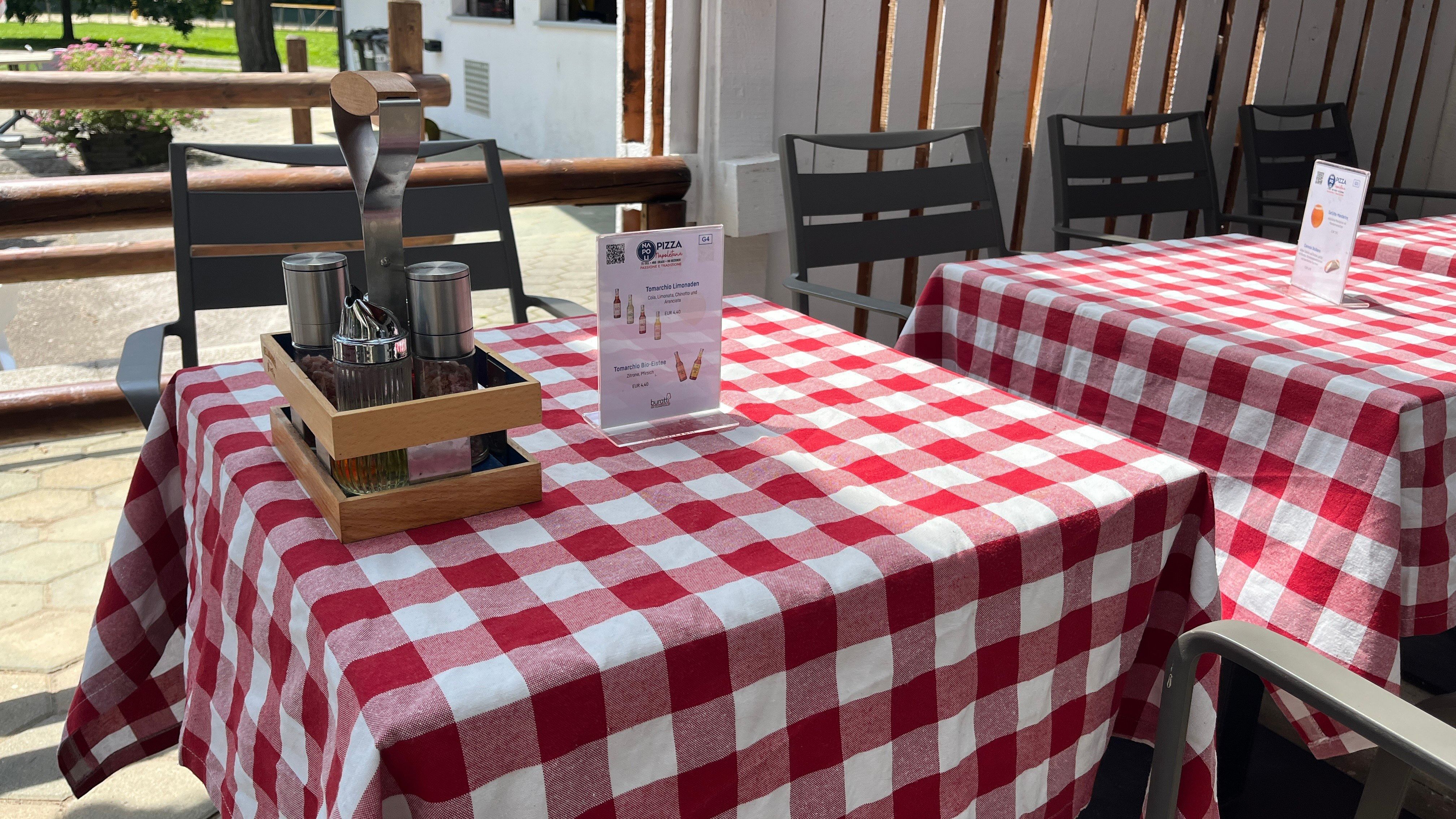 Terített asztal piros terítővel és ételajánlóval.