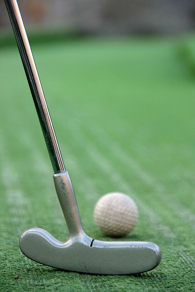 Minigolf ütők a zöld fű előtt 