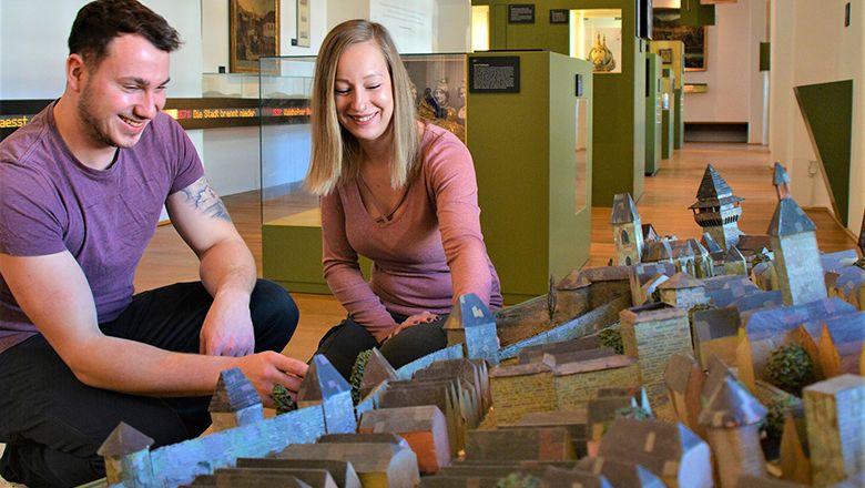 Két ember egy város makettjét nézi egy múzeumban.