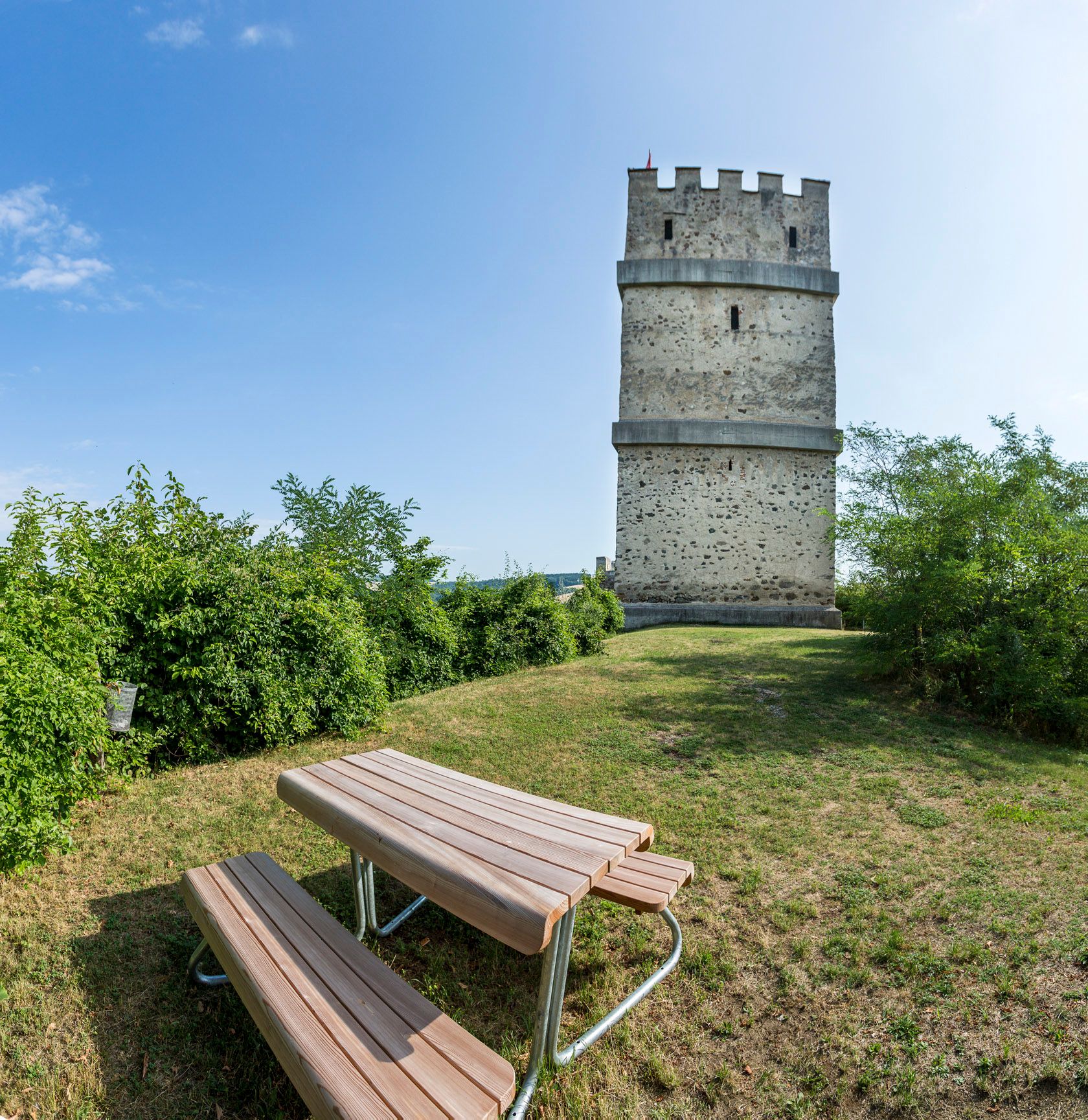 A Kirchschlag-vár romjainak tűztornya, előtérben piknikasztal.