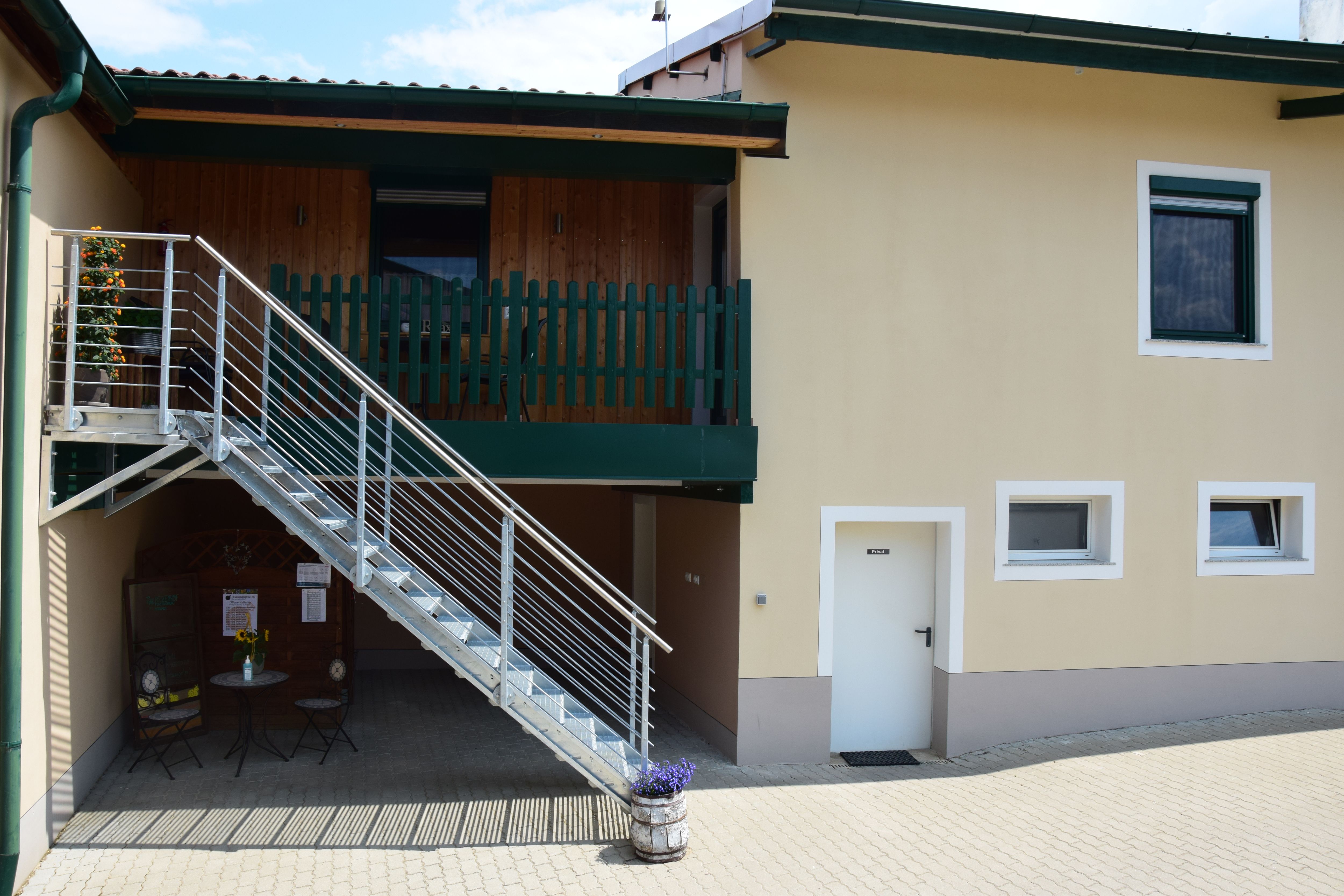 Egy épület külső nézete lépcsővel és erkéllyel.