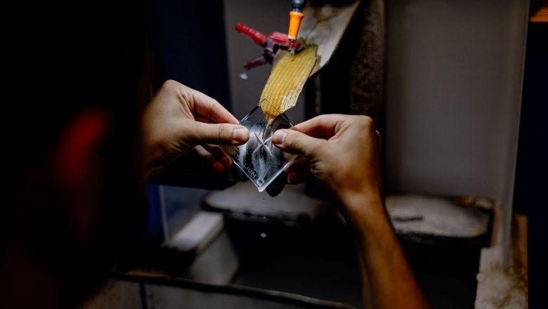 K&ouml;zelk&eacute;p egy &uuml;vegdarabon dolgoz&oacute; kezekről egy csiszol&oacute;g&eacute;pen.