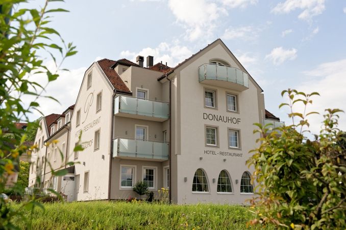 A Hotel Restaurant Donauhof külső nézete az erkélyekkel és a kerttel.