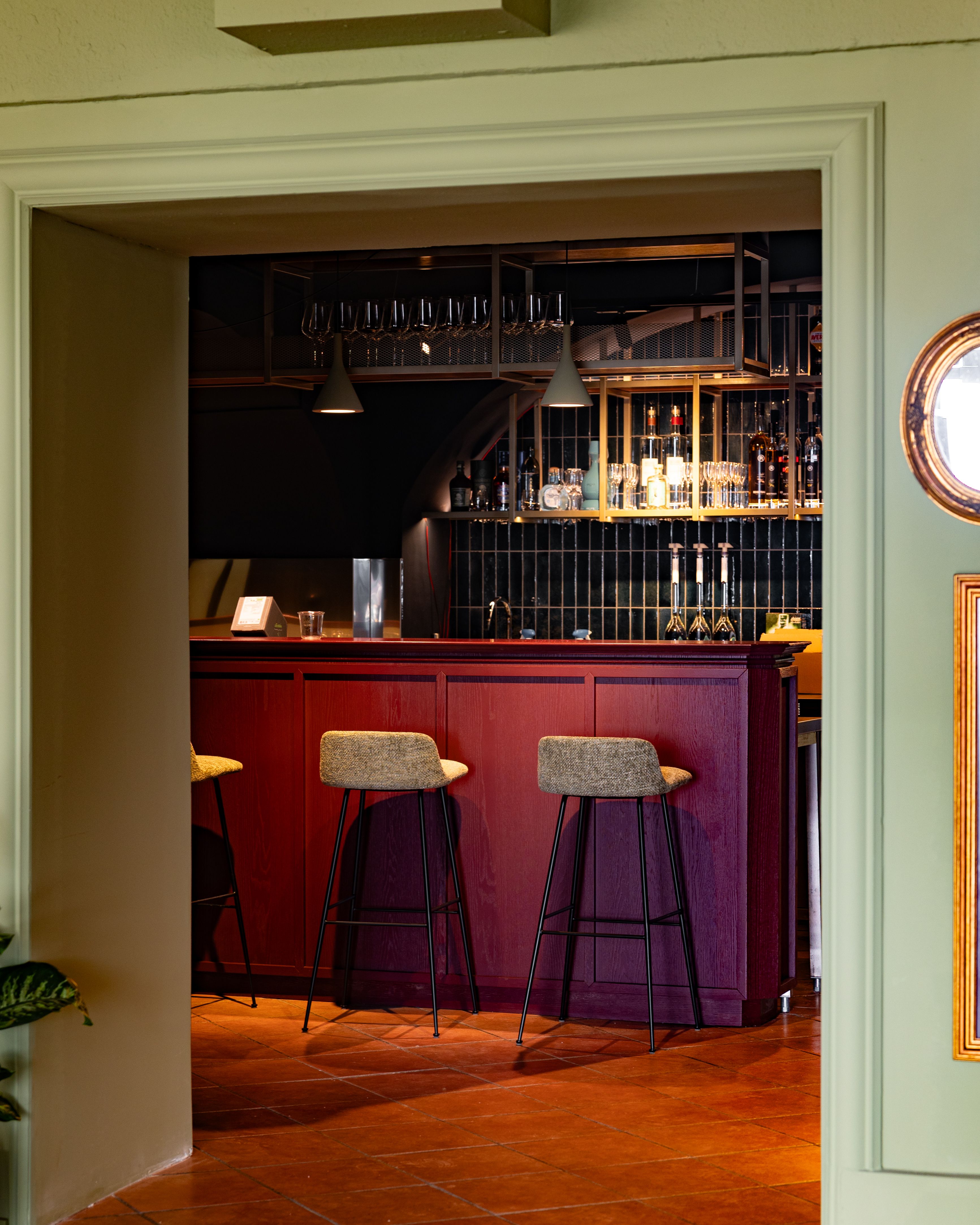 Elegáns bár piros fabútorokkal és magas székekkel.