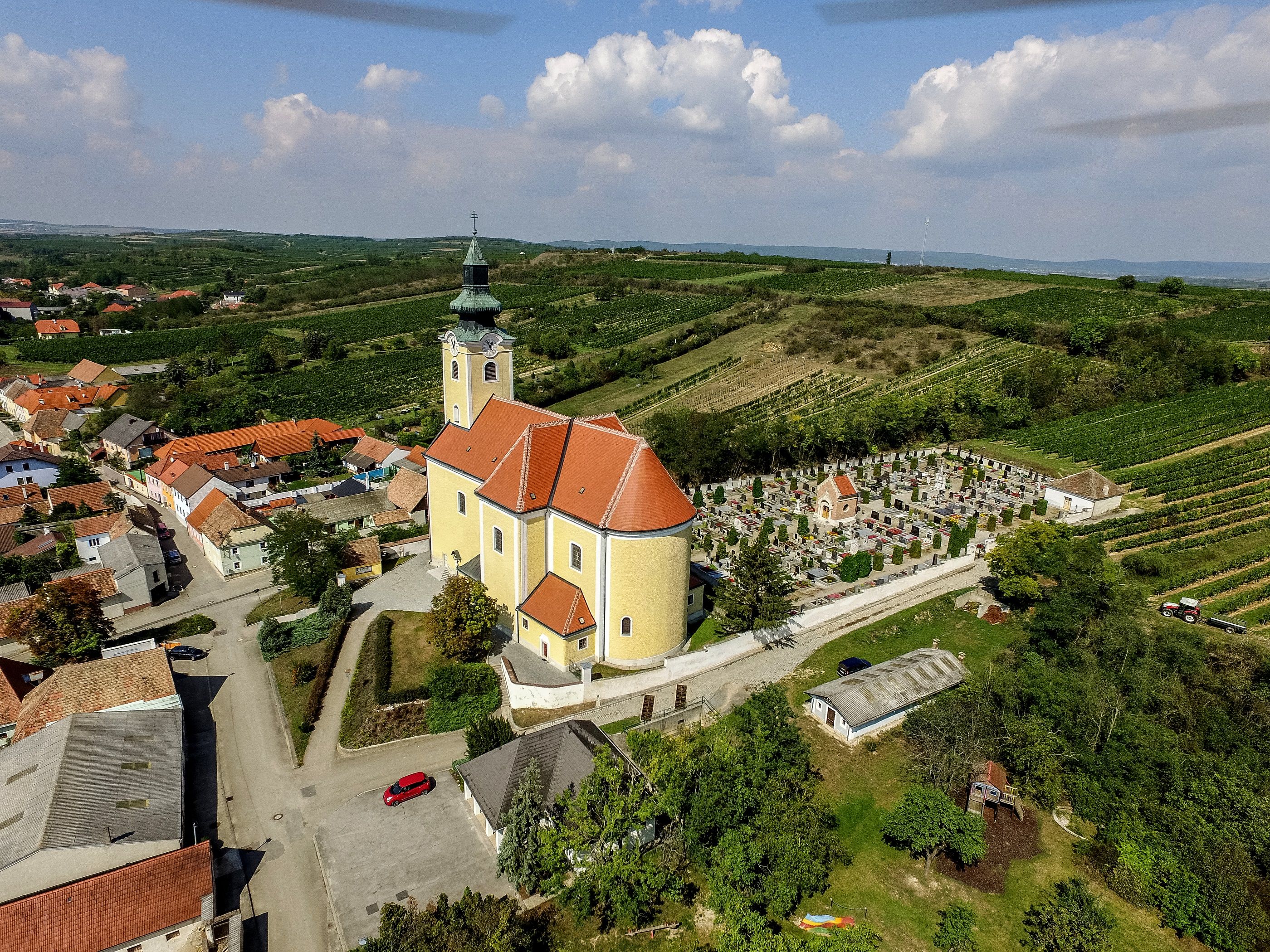 Légi felvétel a röschitzi plébániatemplomról, a környező temetővel és szőlőskertekkel.