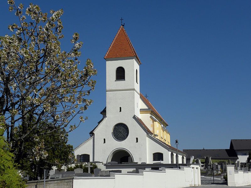 Szent Anna-templom Wiesmathban kék éggel és virágzó fával az előtérben.