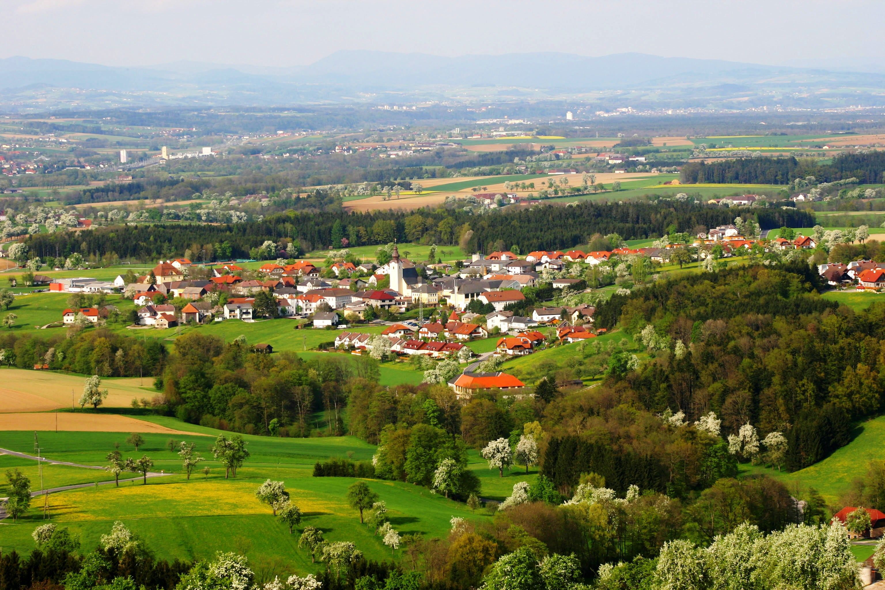 Biberbach település légi képe zöld mezőkkel és erdőkkel.