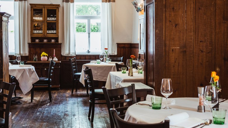 Hangulatos kocsma fabútorokkal és terített asztalokkal.