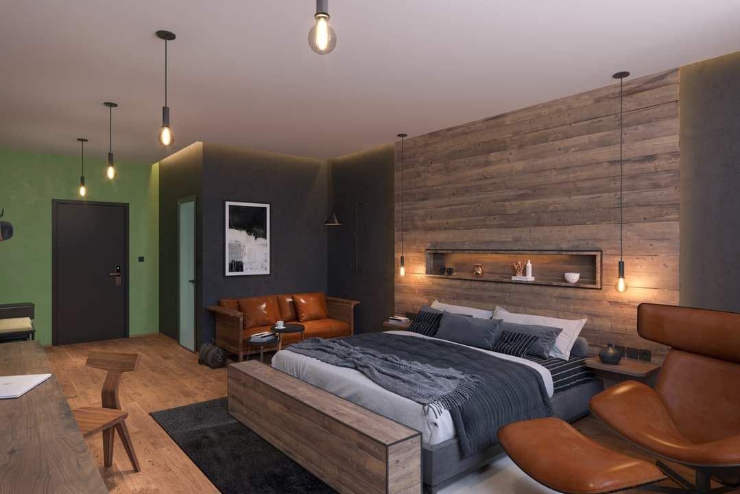 Modern hálószoba fából készült fallal, nagy ággyal, bőrkanapéval és stílusos lámpákkal.