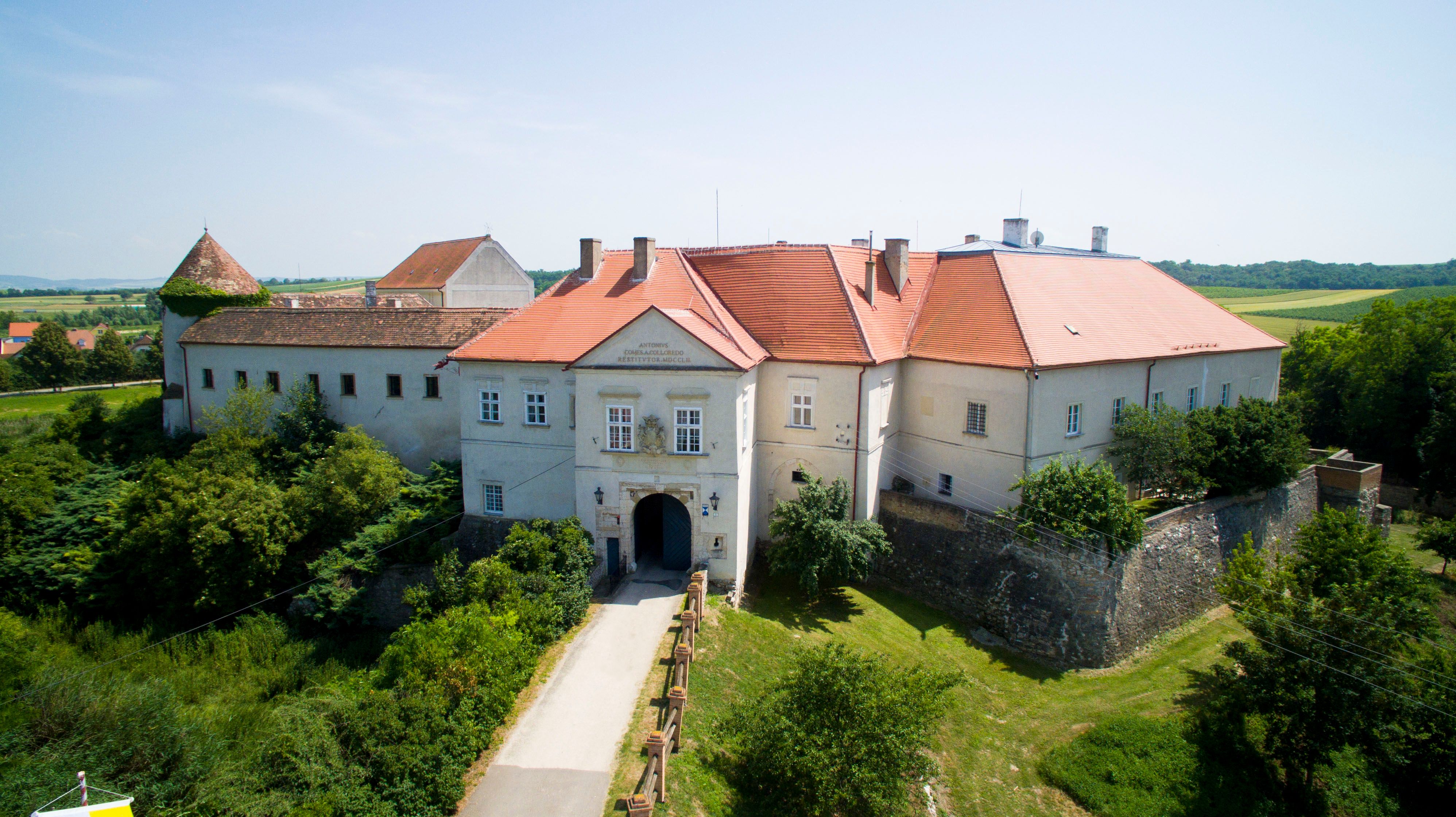 Légi felvétel a Mailbergi kastélyról a vörös tetőkkel és a környező tájjal.