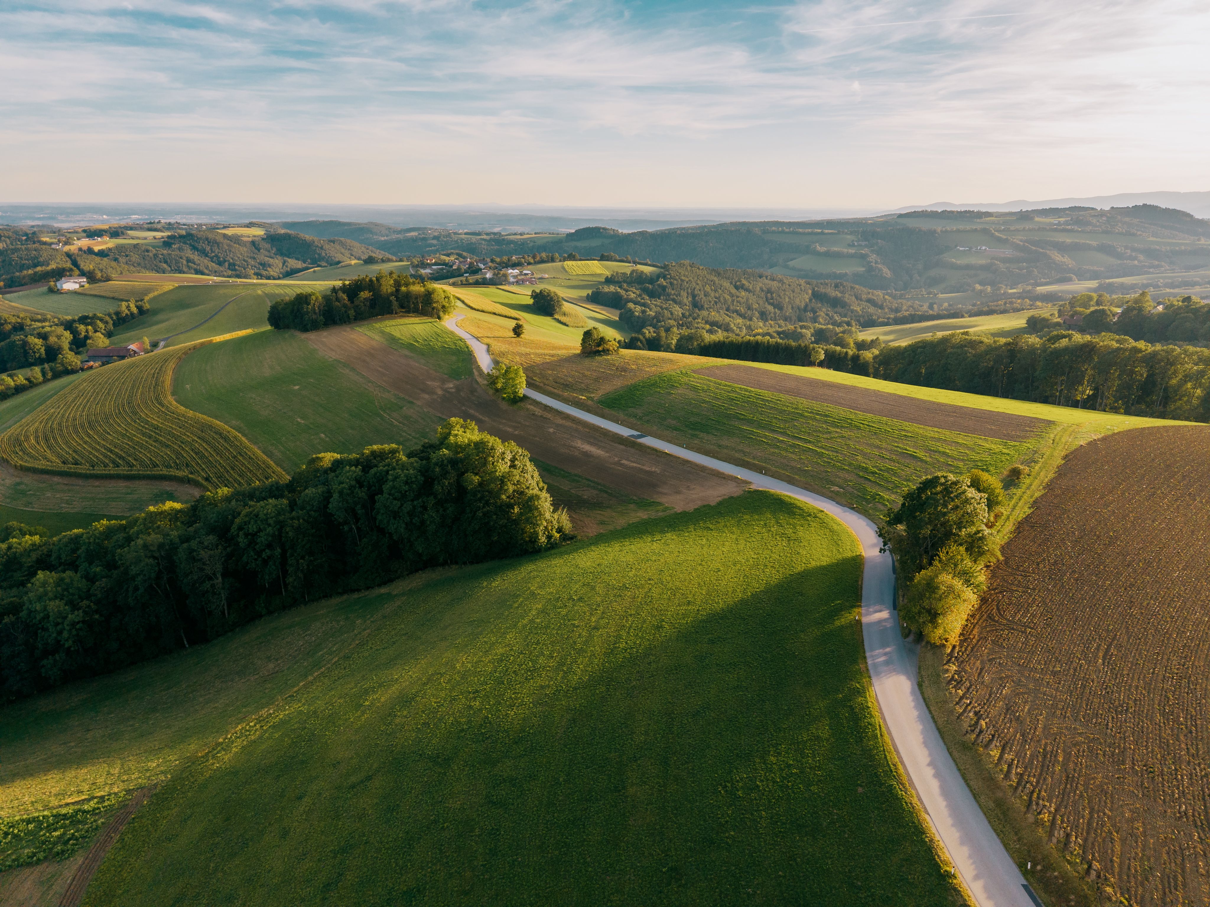 Légi felvétel egy dombos tájról, mezőkkel és erdőkkel Hattmannsdorfban, Hochneukirchenben.