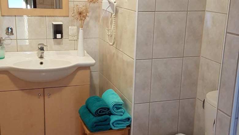 F&uuml;rdőszoba mosd&oacute;val, t&uuml;k&ouml;rrel, WC-vel &eacute;s t&ouml;r&ouml;lk&ouml;zőkkel egy zs&aacute;molyon.