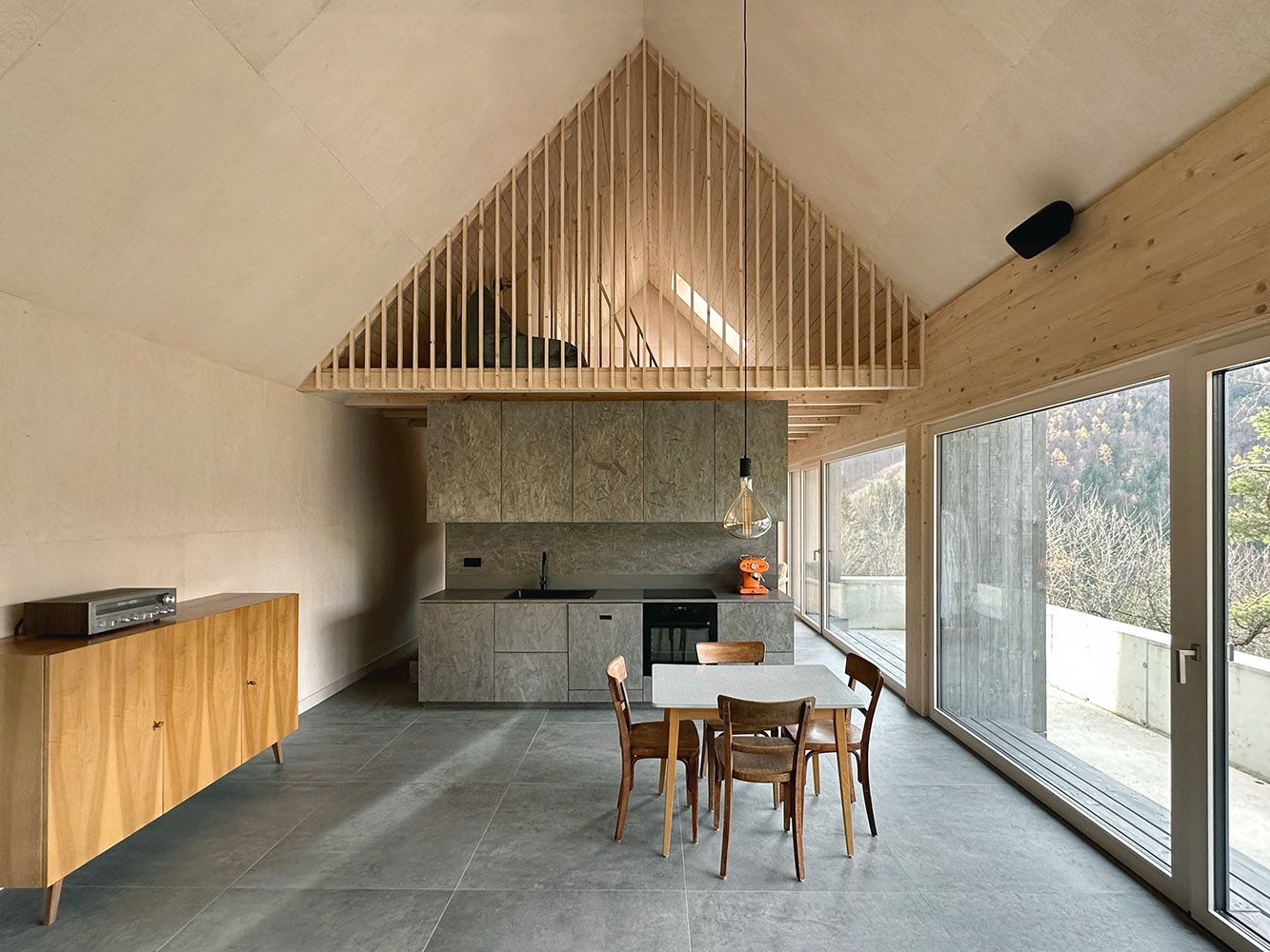 Modern nyitott konyha fa elemekkel és nagy ablakokkal.