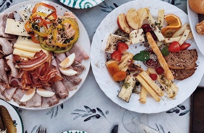 K&eacute;t t&aacute;ny&eacute;r felv&aacute;gottal, sajttal, z&ouml;lds&eacute;ggel &eacute;s gy&uuml;m&ouml;lccsel az asztalon.