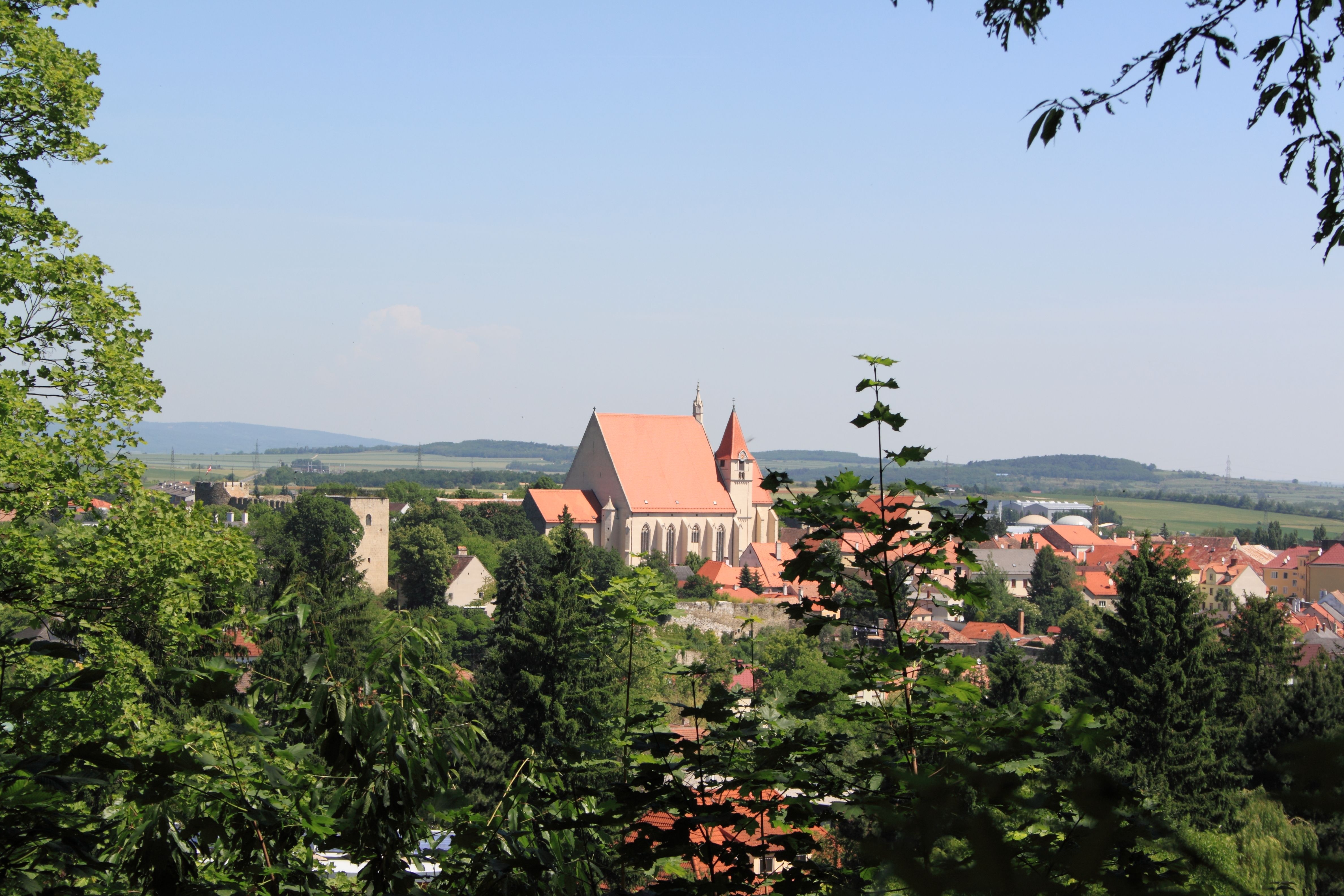 Eggenburg panorámaképe a templommal és a környező épületekkel, a háttérben fákkal és dombokkal.