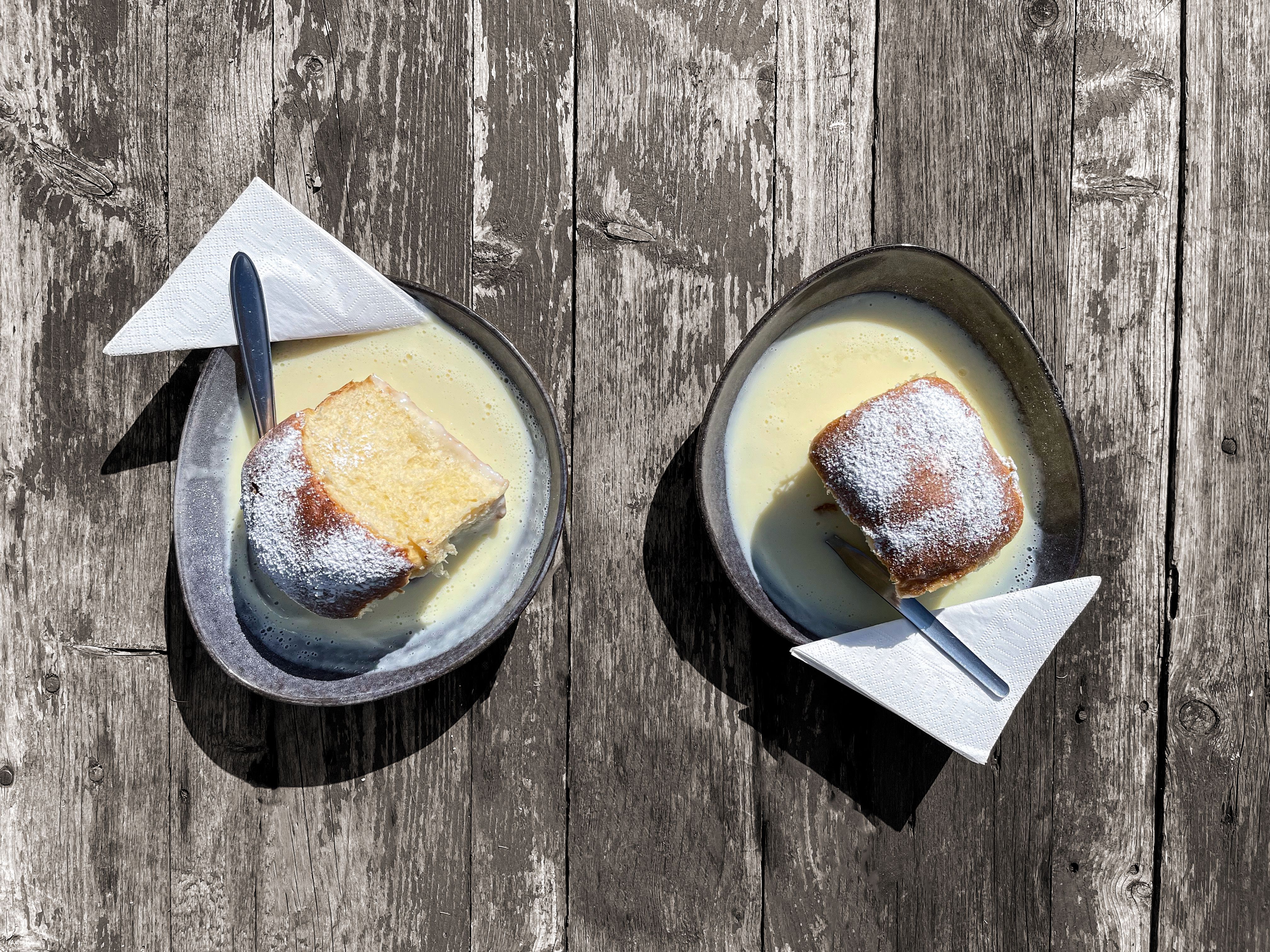 Emberek egy vasútállomáson egy vonattal és egy faépülettel.