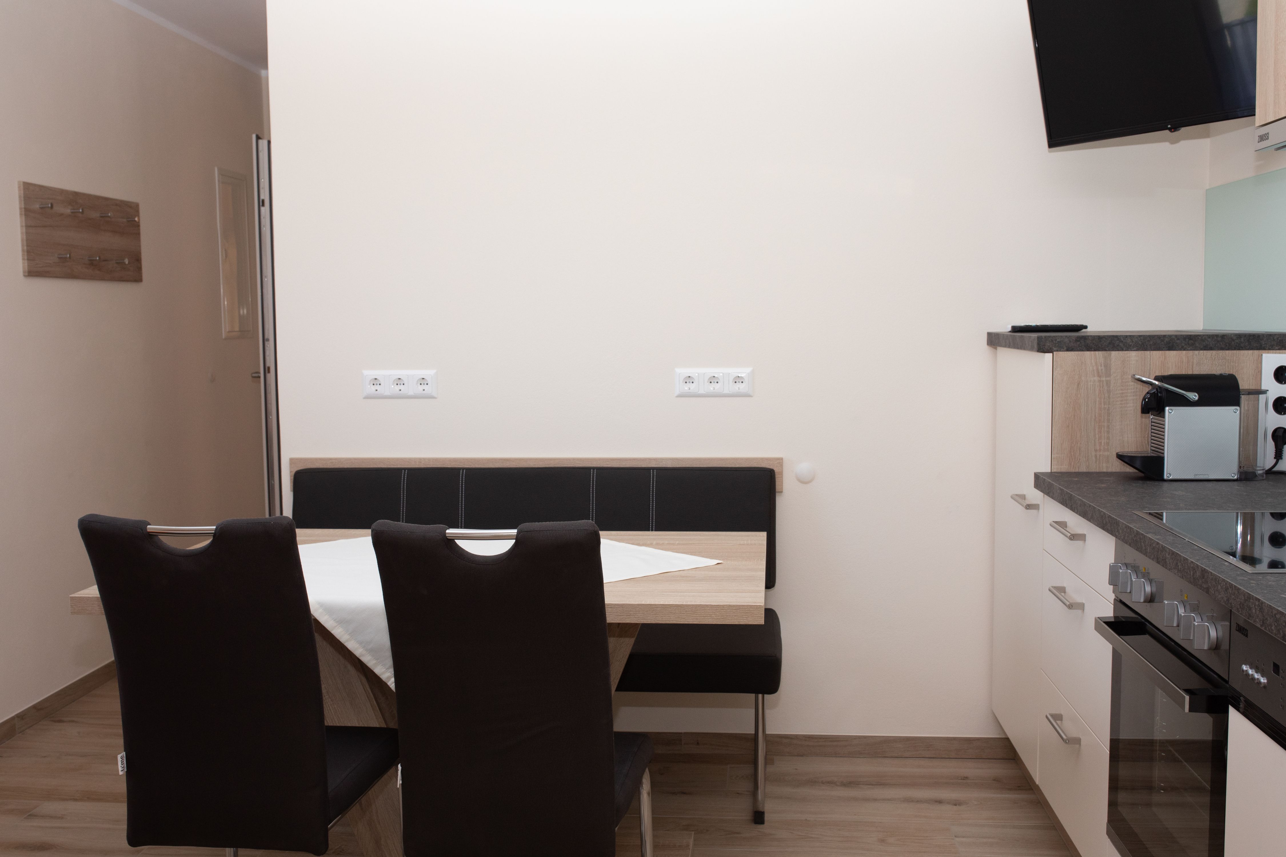 Étkező asztalokkal, székekkel és konyhasarokkal.