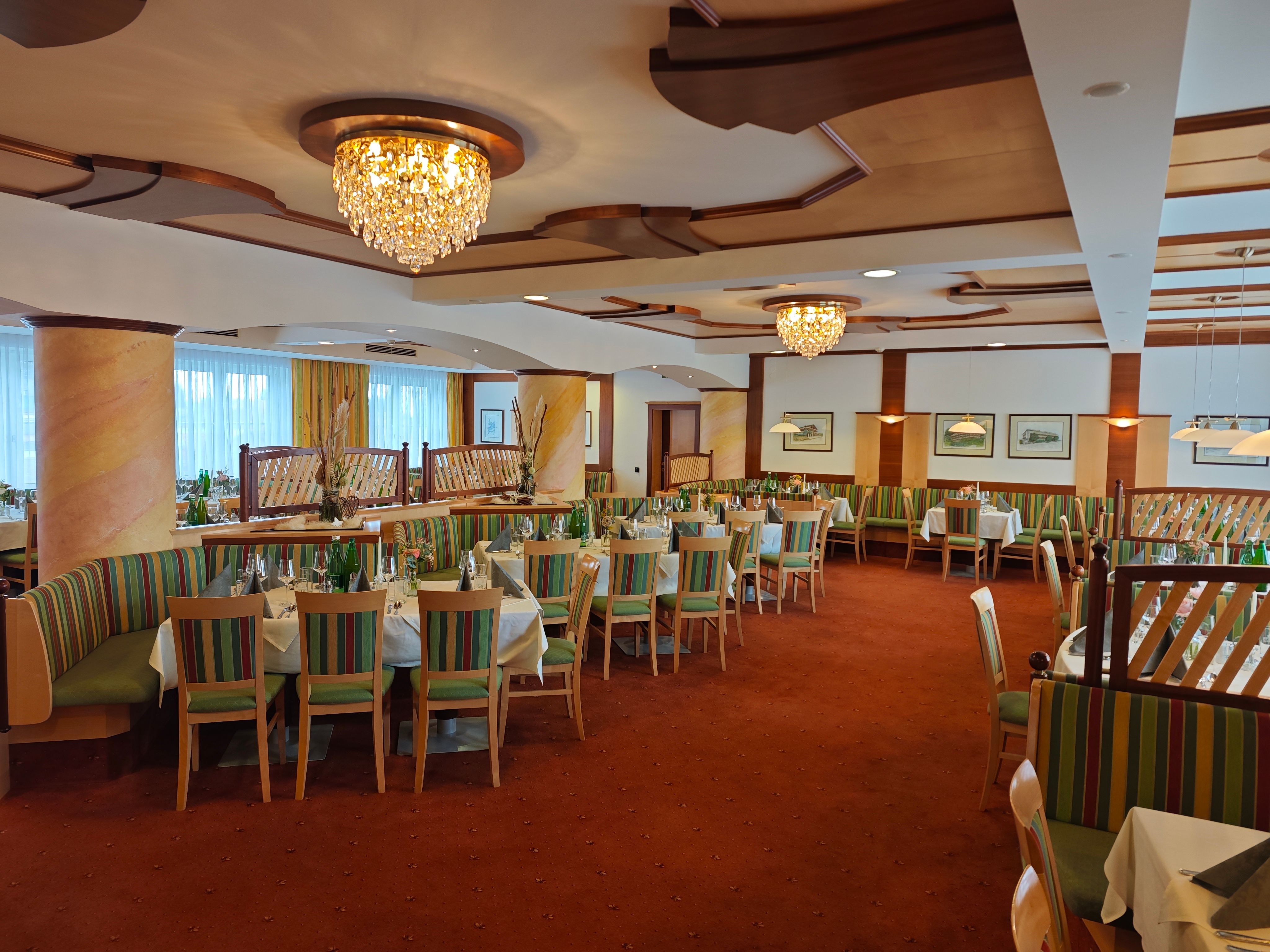 Elegáns étkező csillárokkal és terített asztalokkal a Hotel Thierben.