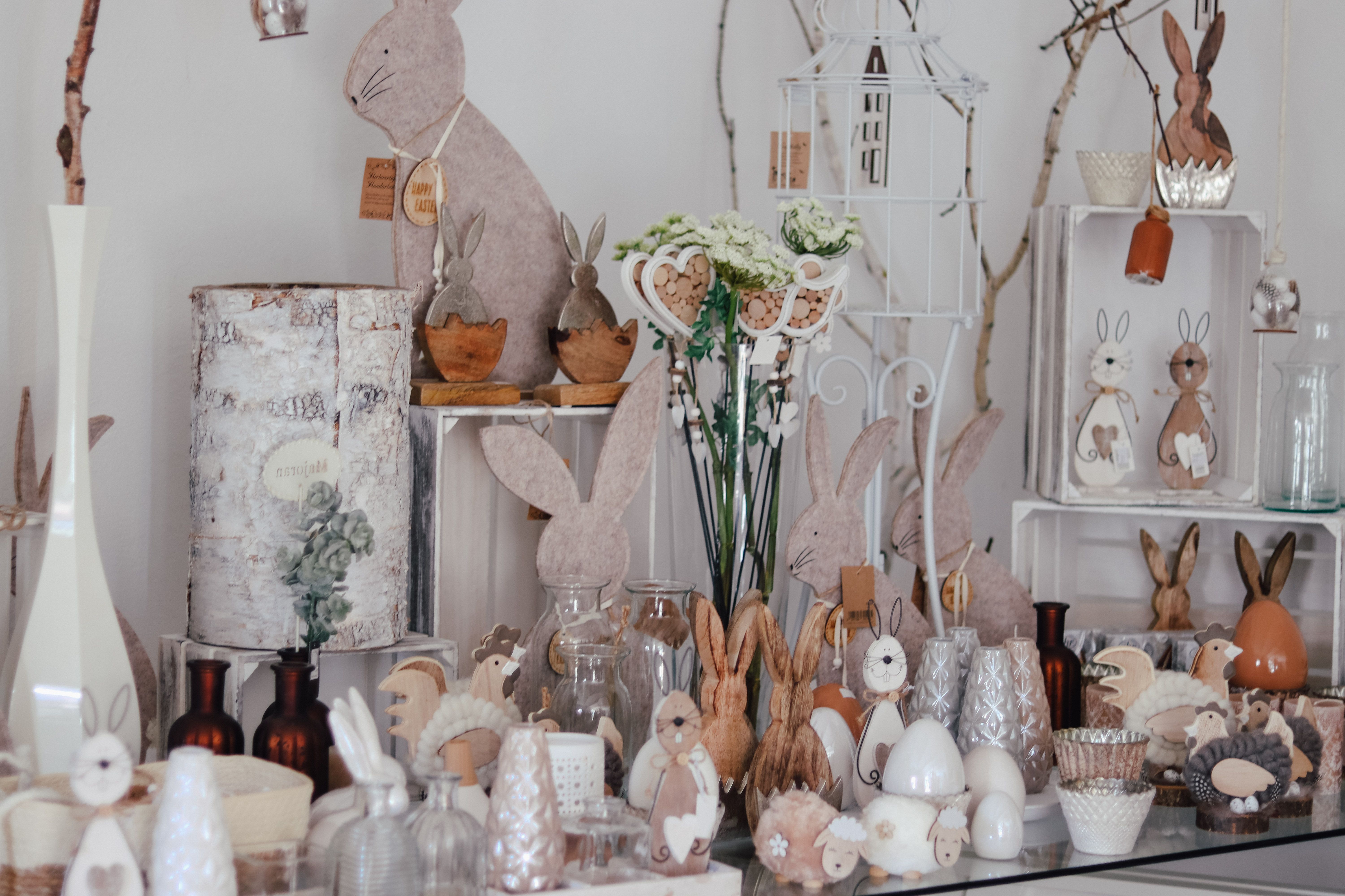 Dekoratív húsvéti nyuszik és tavaszi dekorációk egy asztalon.
