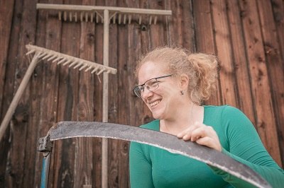 Julia grinding the scythe, © Einkehrhof Poggau