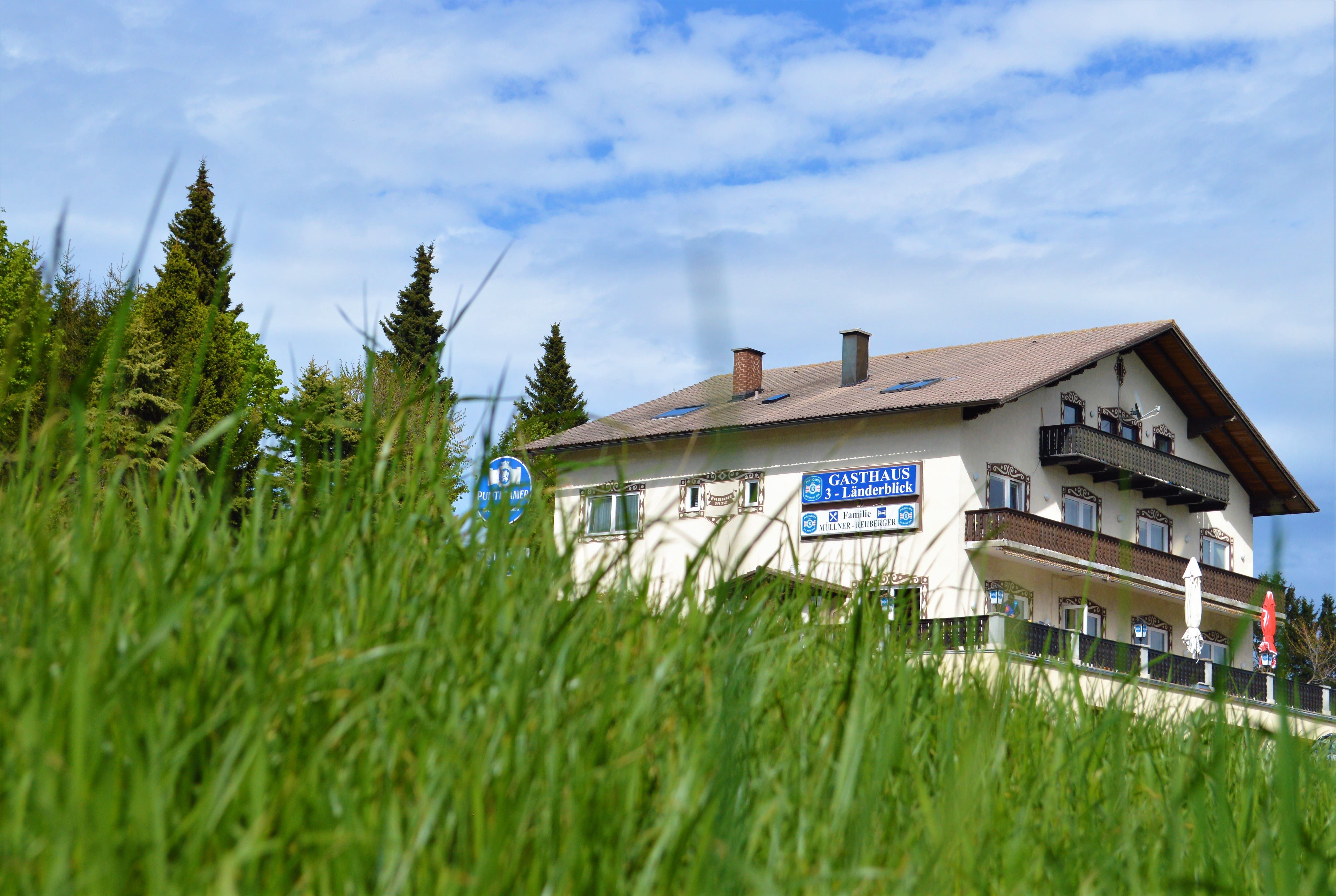 Gasthaus 3-Länderblick egy rét mögött, a háttérben fákkal.