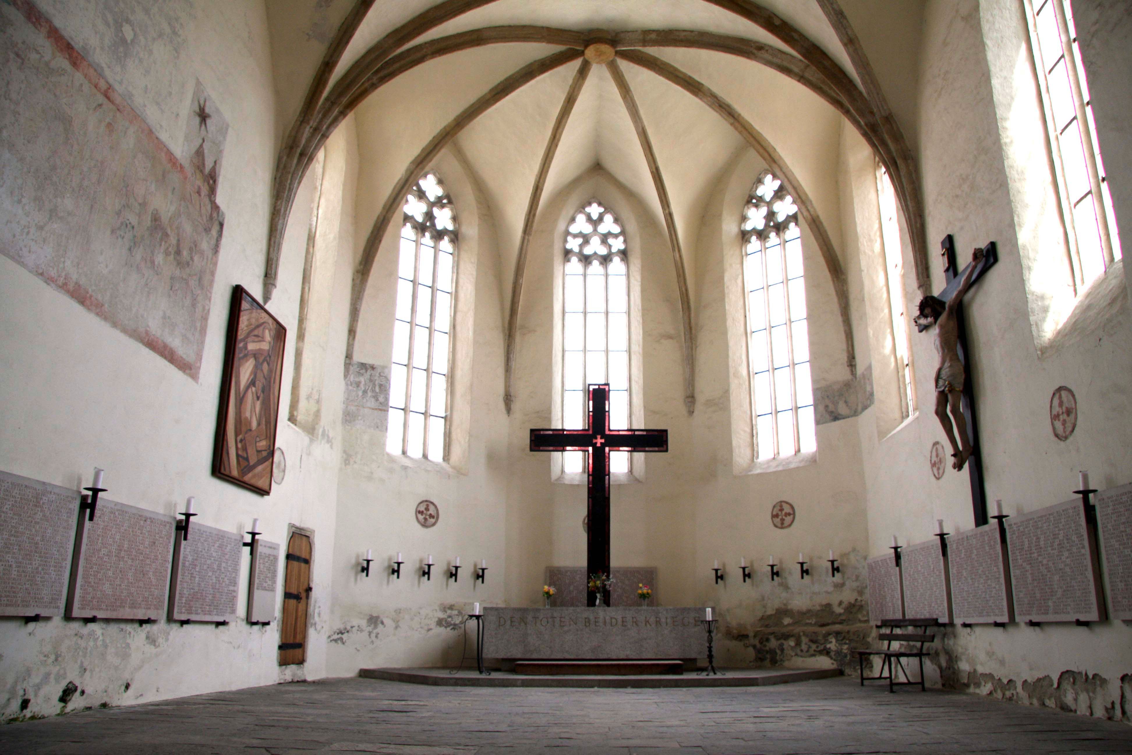 A Frauenbergkirche Stein belső nézete gótikus ablakokkal és egy nagy kereszttel.
