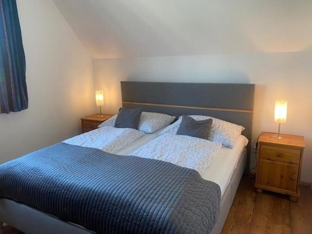 Hangulatos hálószoba franciaággyal, két éjjeliszekrénnyel és lámpákkal.