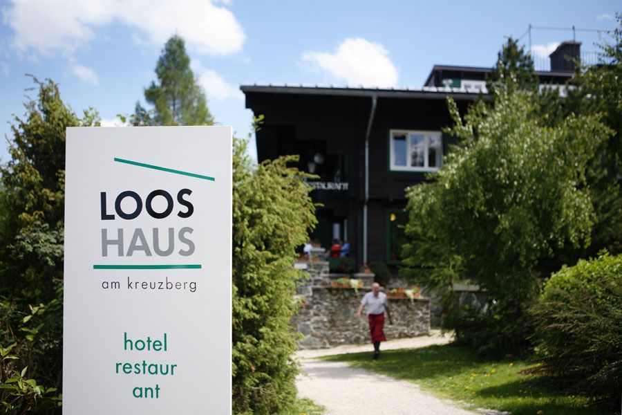 A Looshaus am Kreuzberg bejárata táblával és kerttel.