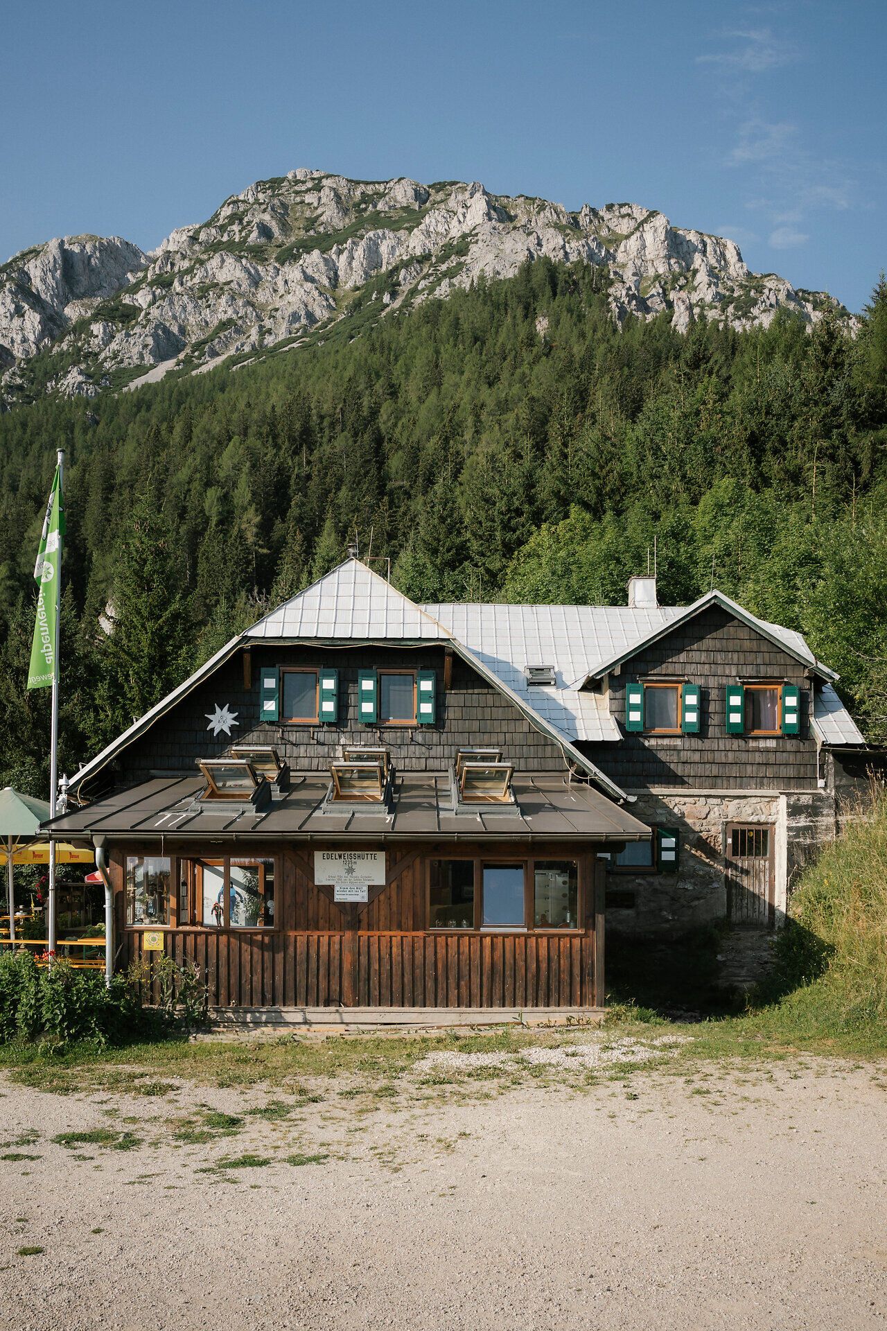 Az Edelweißhütte külső látképe a Schneeberg-hegyen, háttérben a sziklamasszívummal