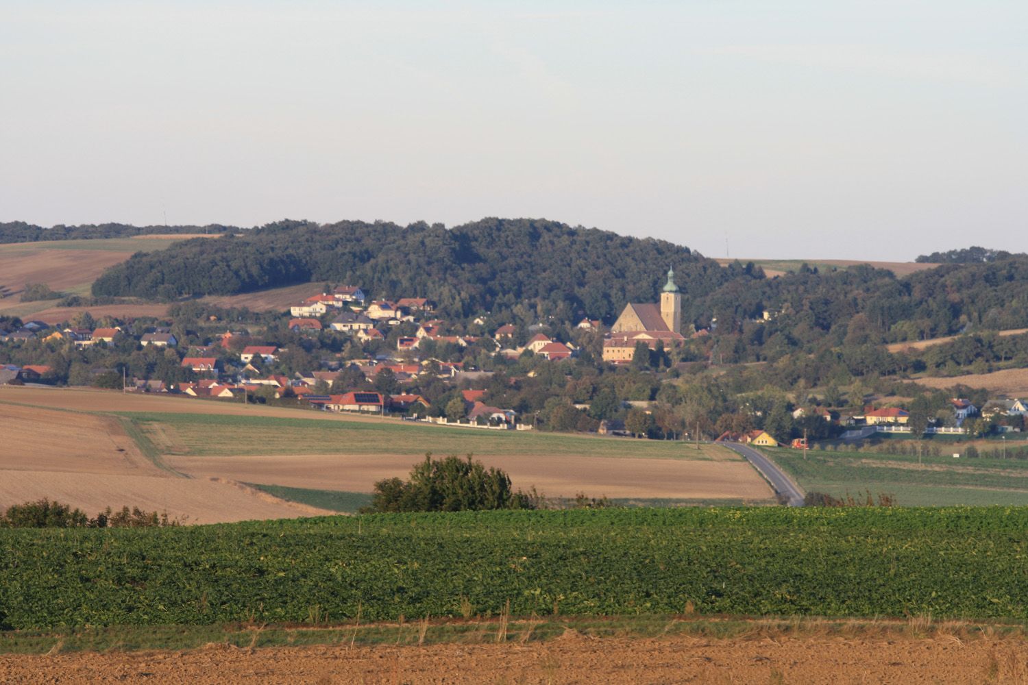 Großrußbach panorámája a templommal és a környező mezőkkel.