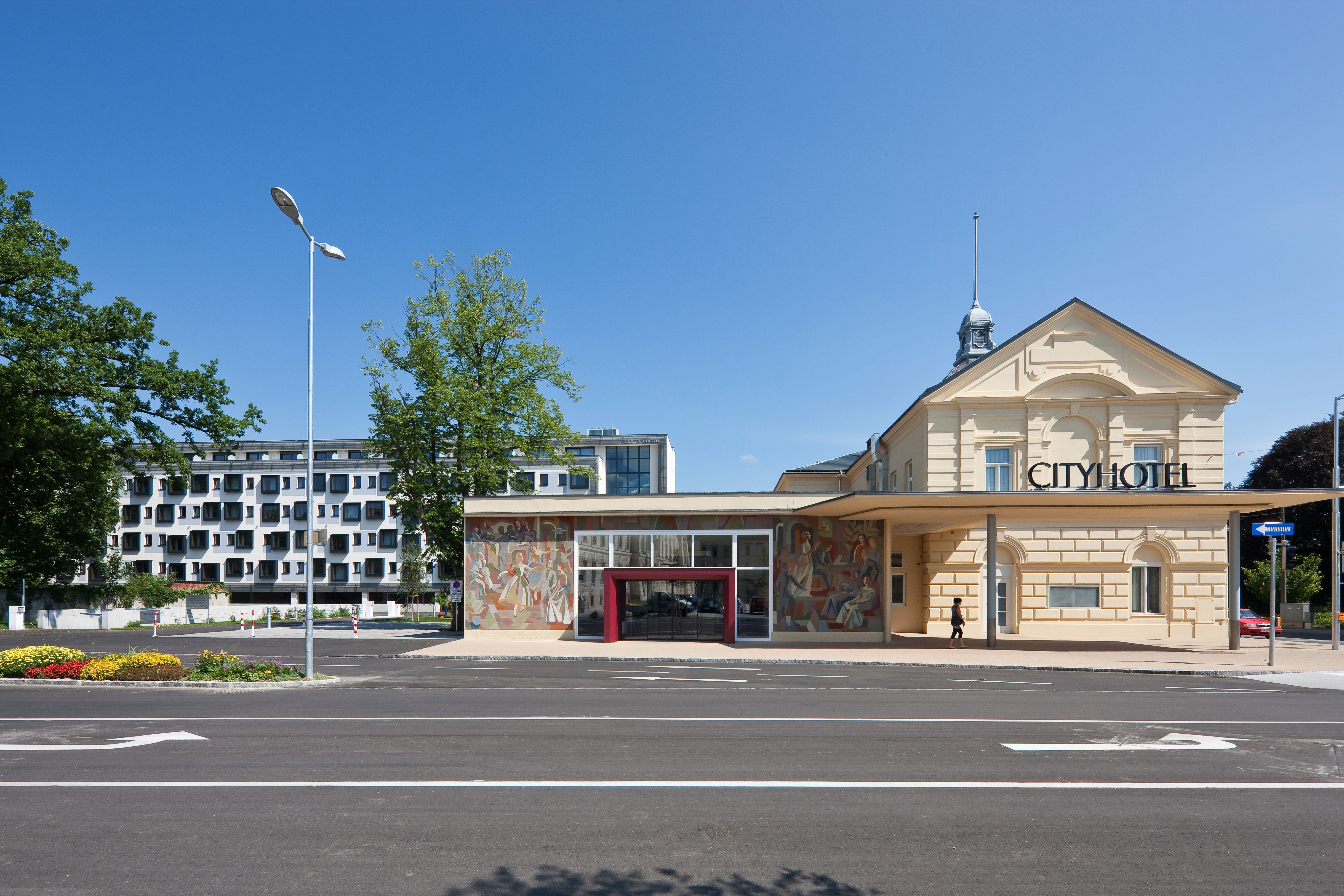 A Cityhotel D & C külső nézete az épület modern és történelmi részeivel.