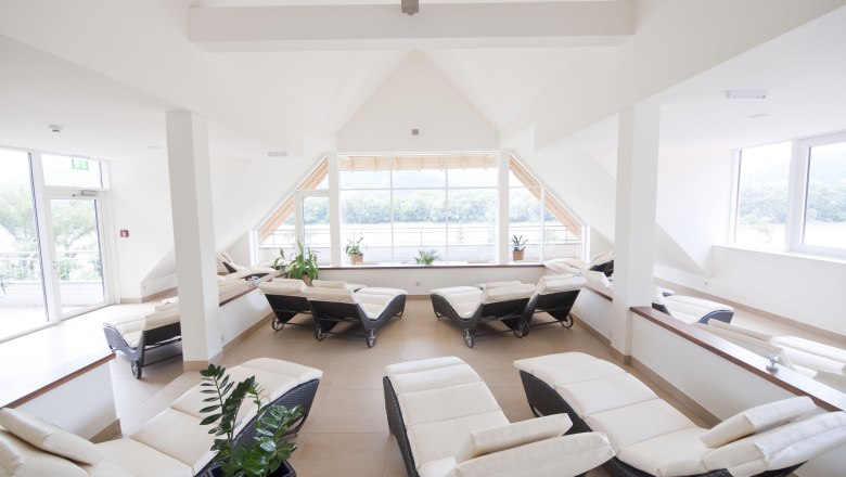 Vil&aacute;gos wellness-szoba nyug&aacute;gyakkal &eacute;s nagy ablakokkal.