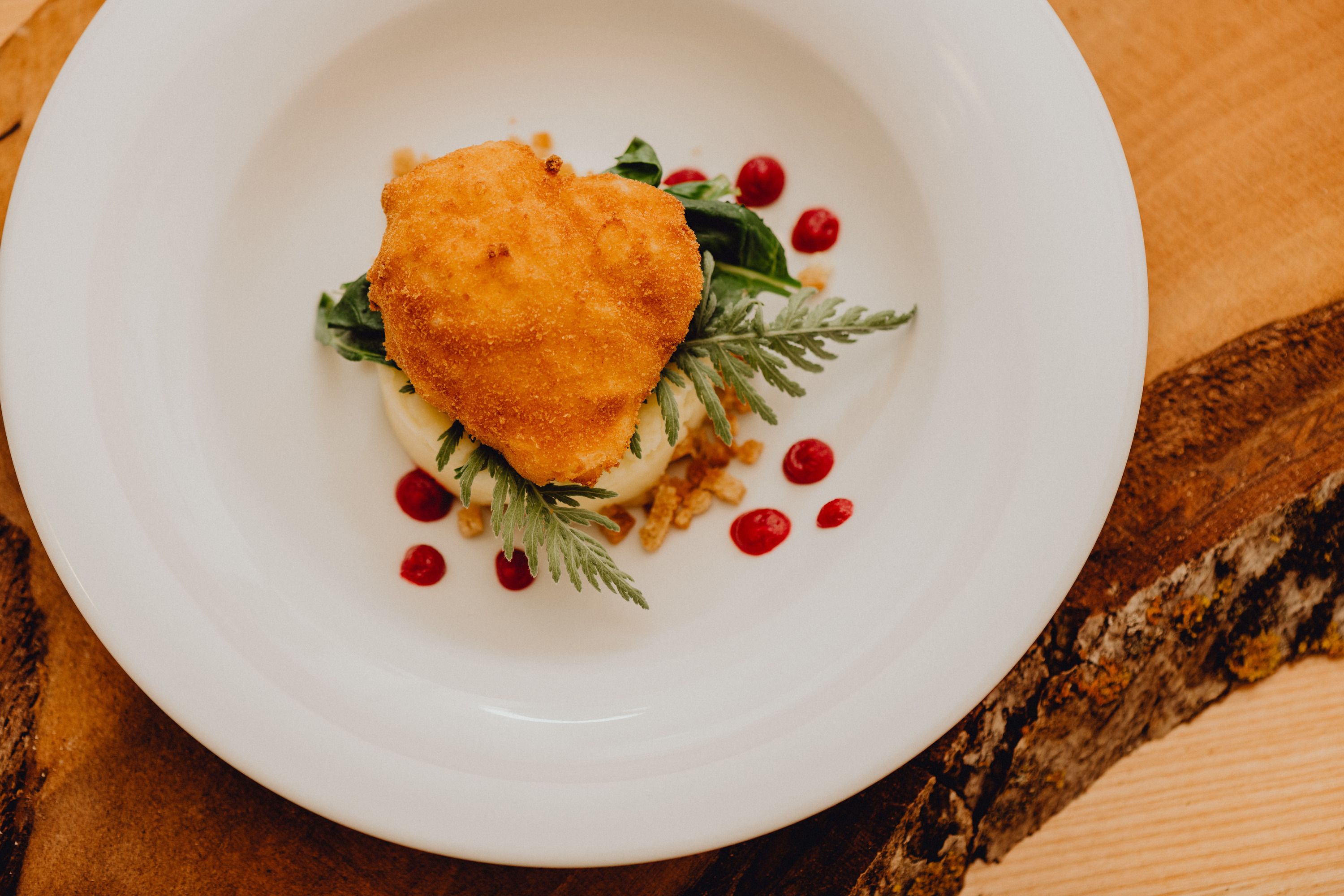 Egy tányéron sült tojás pürével és piros pöttyökkel.