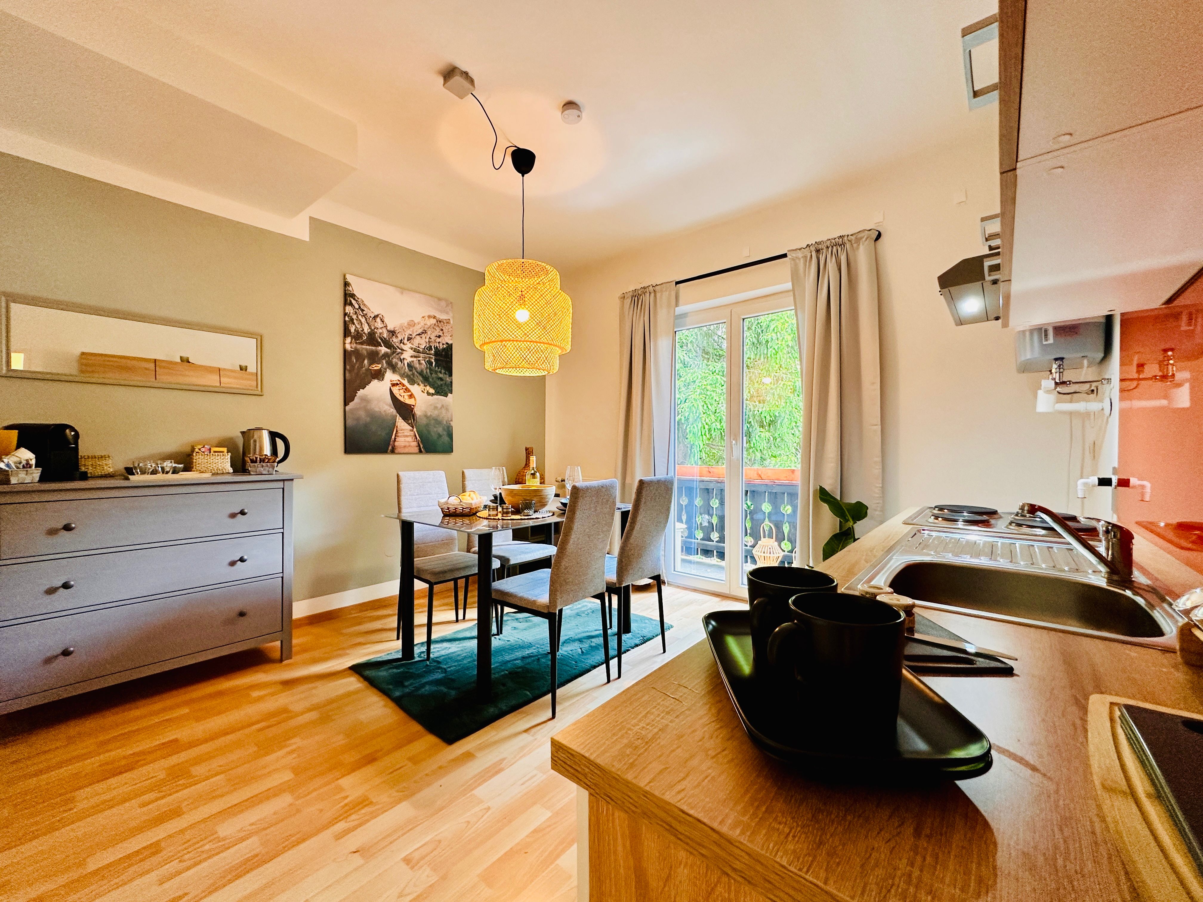 Hangulatos lakás étkezőasztallal, konyhasarokkal és erkéllyel.