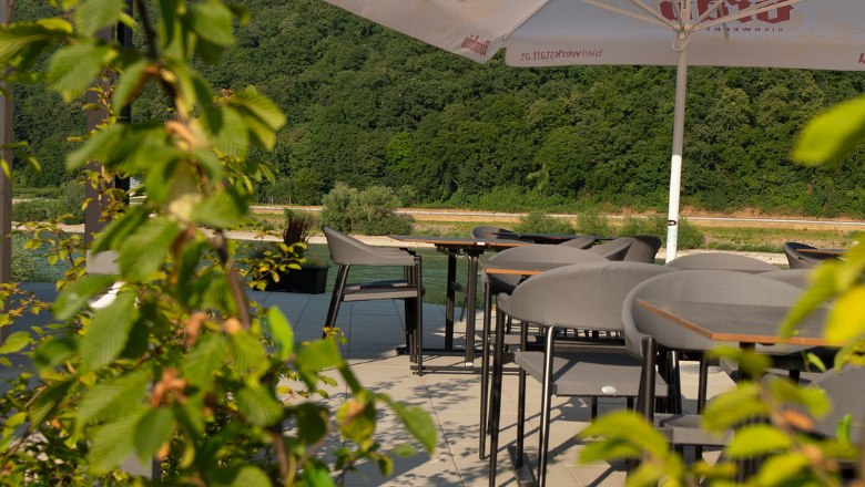 Asztalok a teraszon z&ouml;ld n&ouml;v&eacute;nyekkel