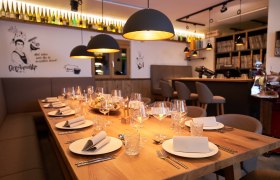 Eleganter, gedeckter Tisch in einem stilvollen Restaurant mit warmem Licht und moderner Dekoration.