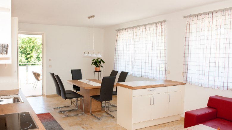 Modern &eacute;tkező, fa asztallal, fekete sz&eacute;kekkel &eacute;s nagy ablakokkal, f&uuml;gg&ouml;ny&ouml;kkel.