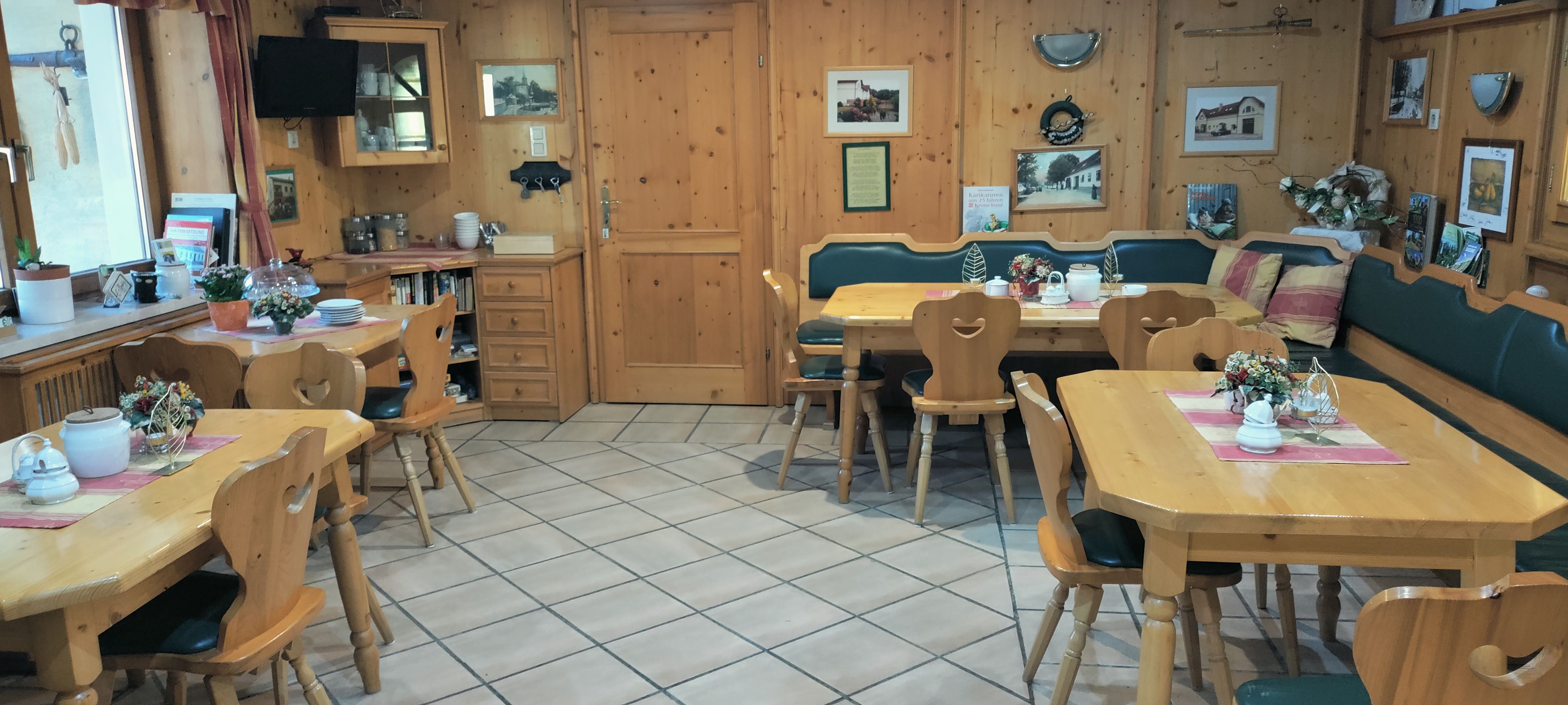 Hangulatos, fából készült bútorokkal és dekorációval berendezett reggelizőterem.