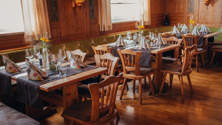 Hangulatos étterem fabútorokkal és terített asztalokkal.