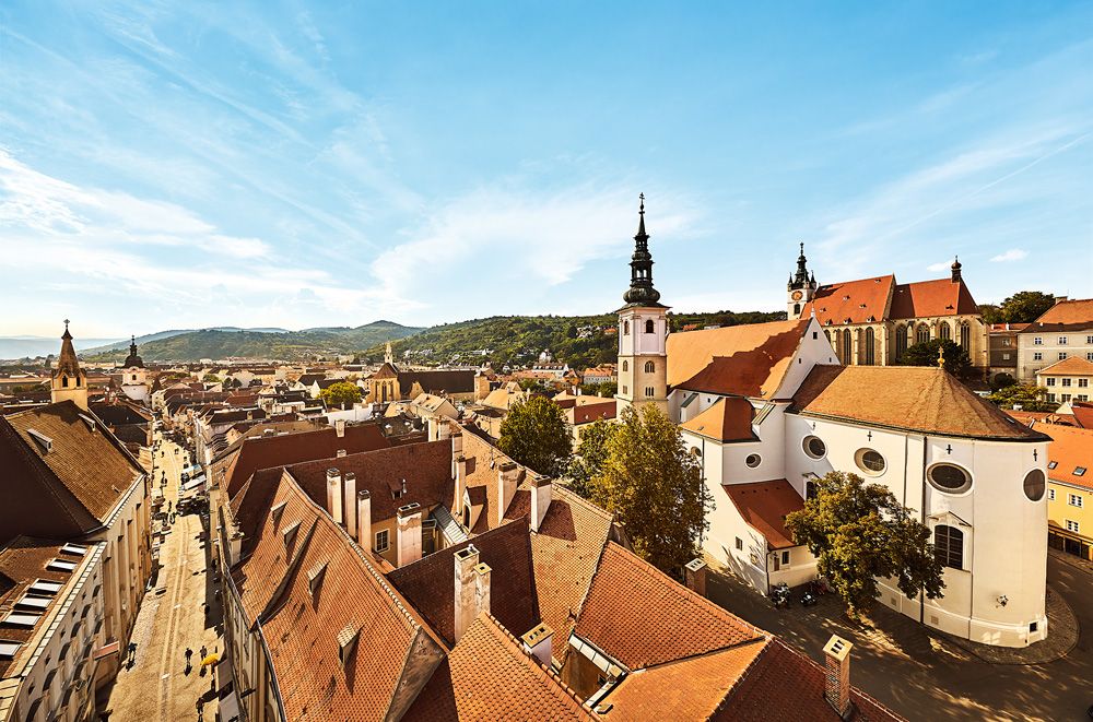 Krems régi városközpontjának panorámája a templomokkal és a vörös tetőkkel.