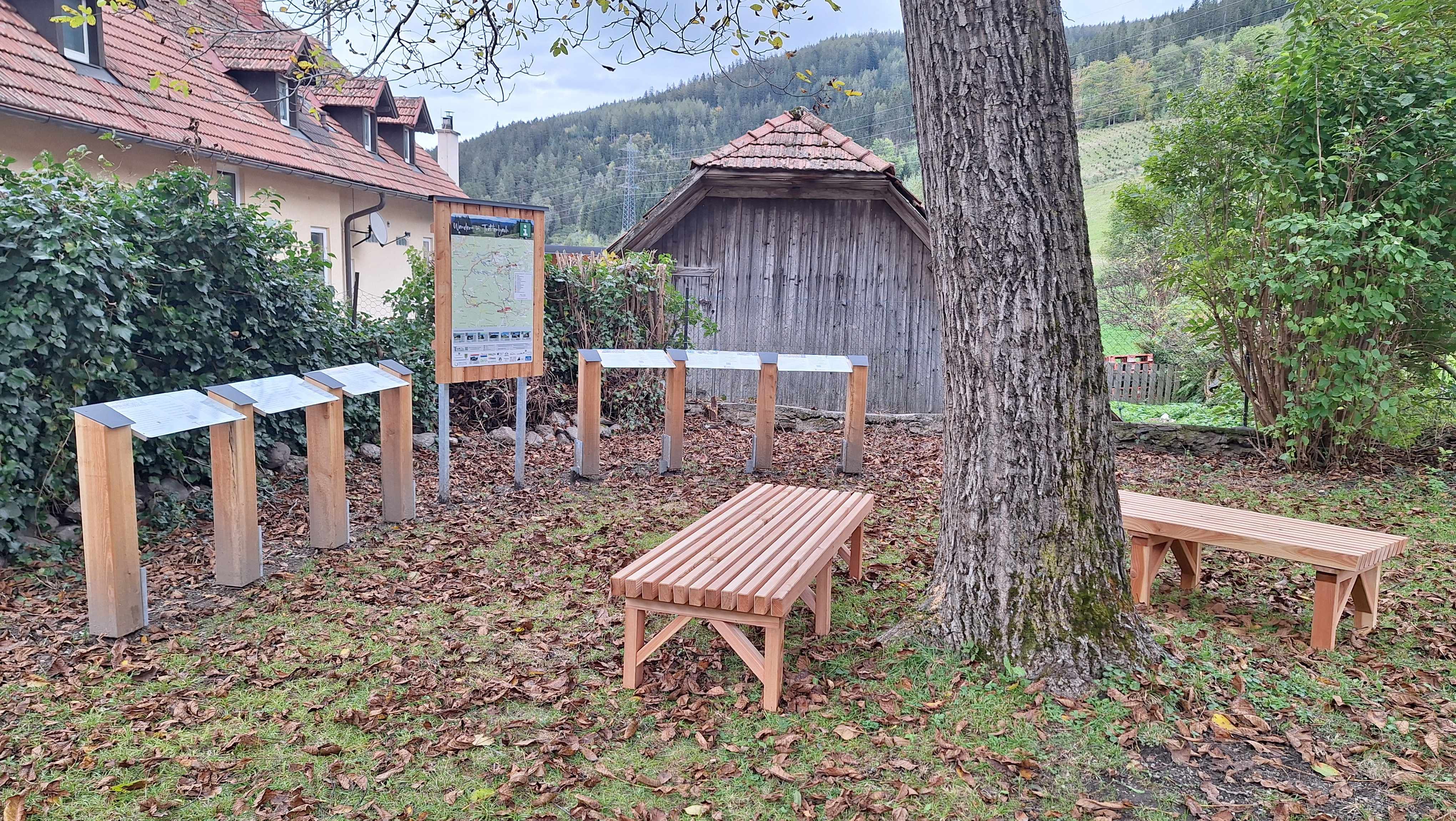 Fapadok és információs táblák a Wittgensteinhaus kertjében.