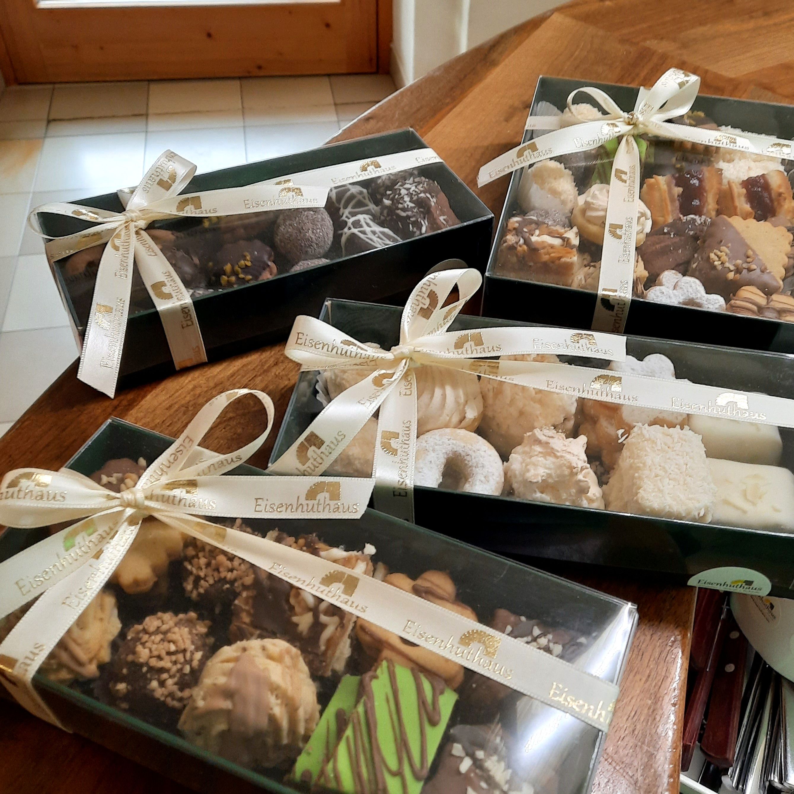 Ajándékdobozok karácsonyi kekszekkel egy asztalon.