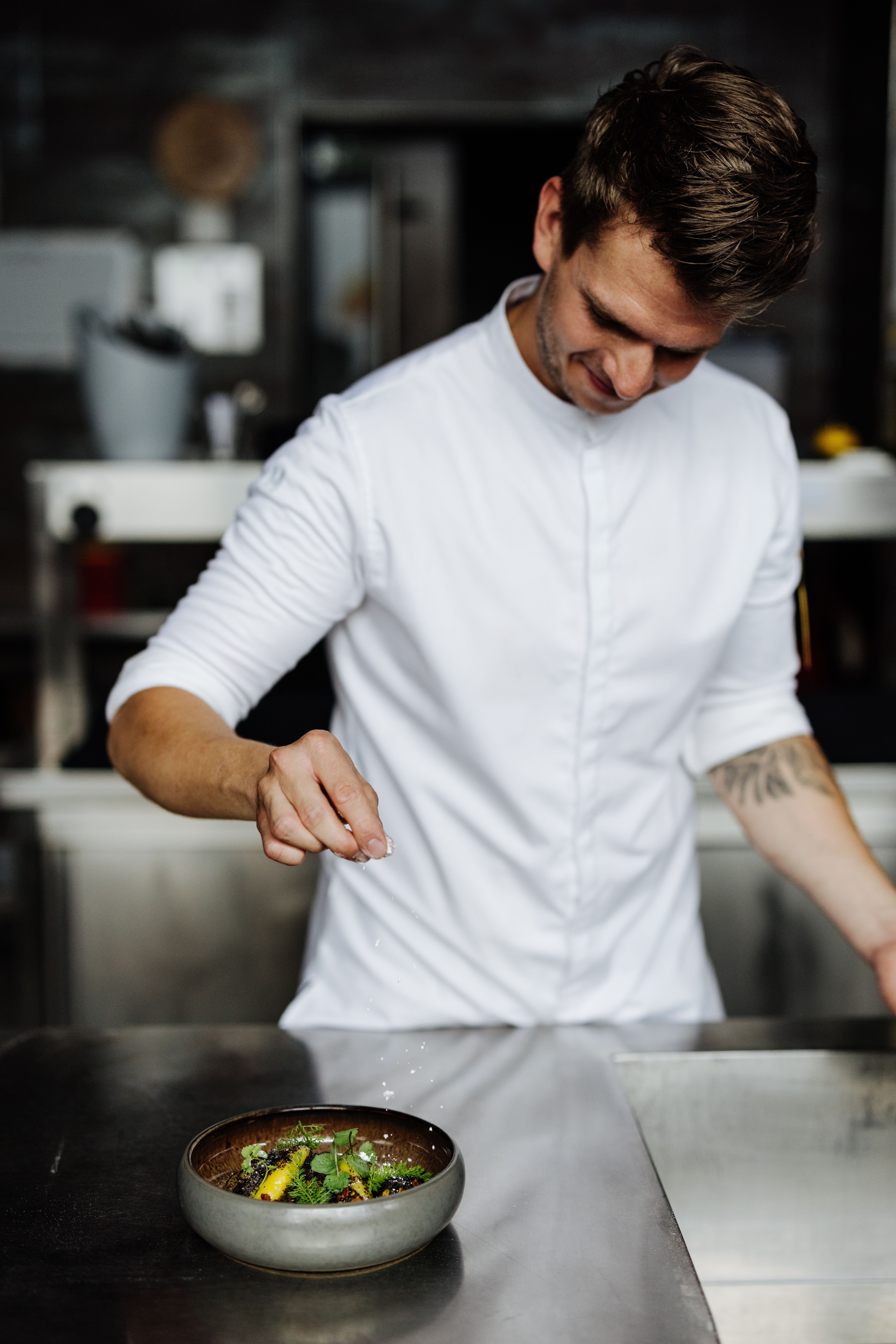 Elegáns étterem kerek asztalokkal, fehér terítőkkel és visszafogott világítással.