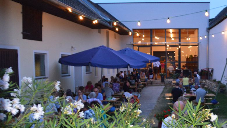 Borozó vendégekkel kint, tündérfényekkel megvilágítva.