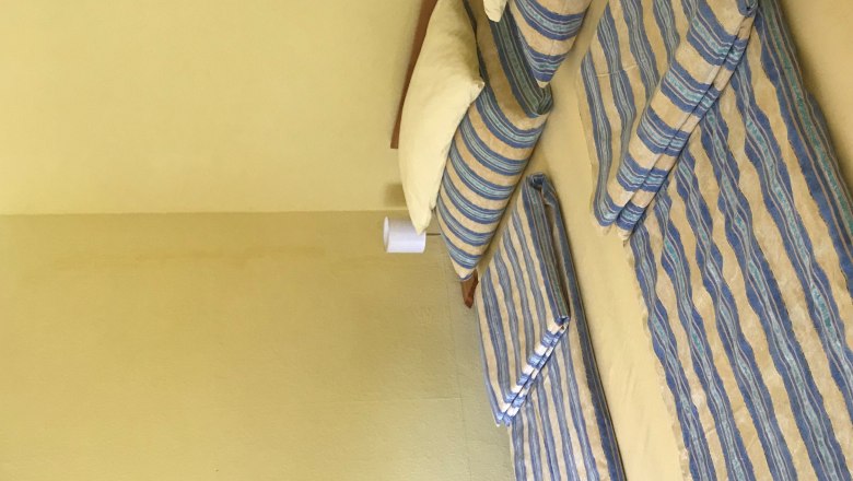 H&aacute;l&oacute;szoba francia&aacute;ggyal, cs&iacute;kos &aacute;gyneművel, s&aacute;rga falak, kis k&eacute;p a falon.