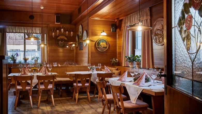 Hangulatos, faburkolatos kocsma, ter&iacute;tett asztalokkal, sz&eacute;kekkel &eacute;s dekorat&iacute;v elemekkel a falakon.