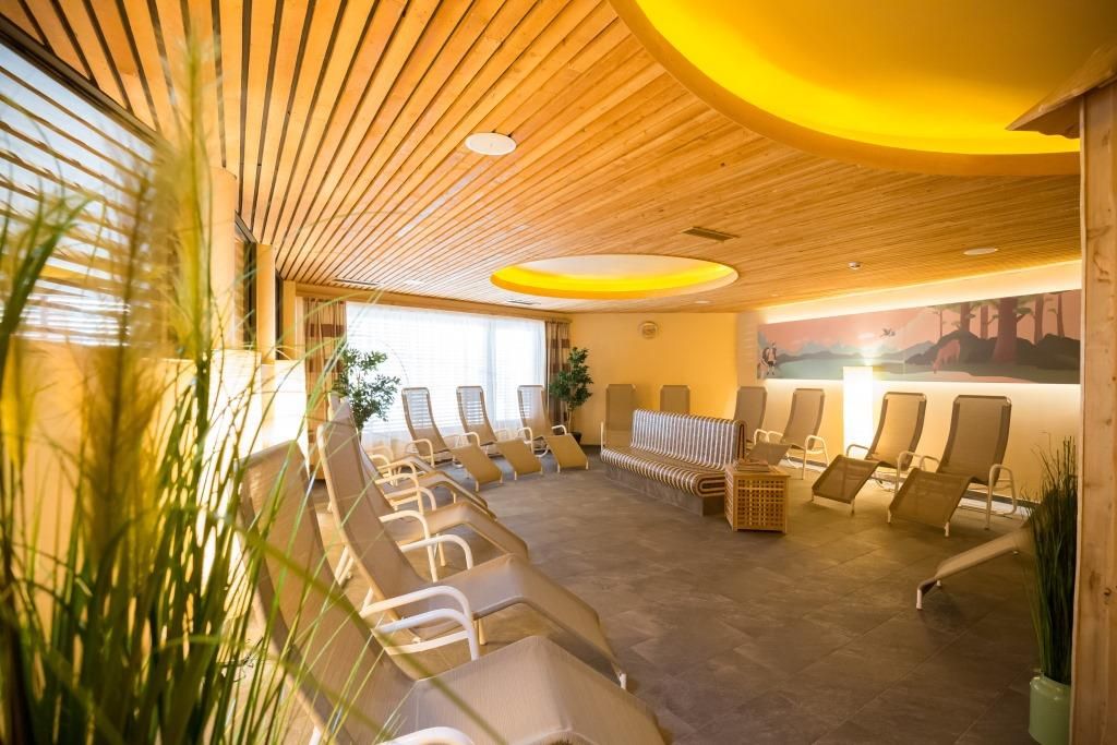 A JUFA Hotel Annaberg modern szaunavilága nyugágyakkal és faelemekkel.